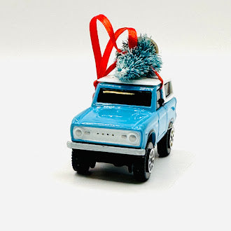 Light blue vintage Ford Bronco Christmas ornament with tree - front view