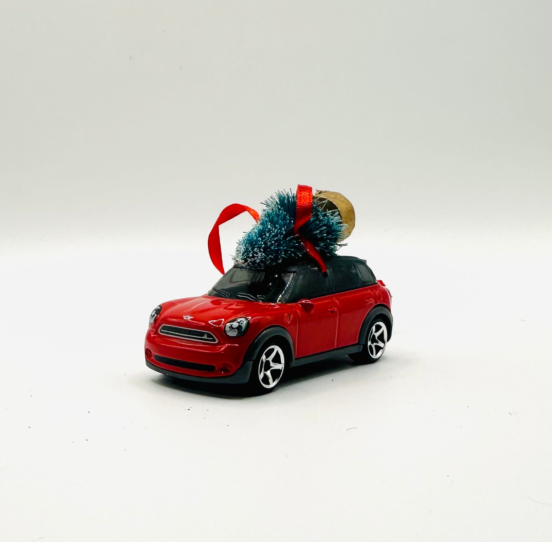 Red toy car with a Christmas tree on a white background