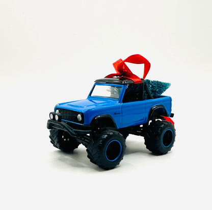 Lifted blue Ford Bronco ornament with monster tires and Christmas tree