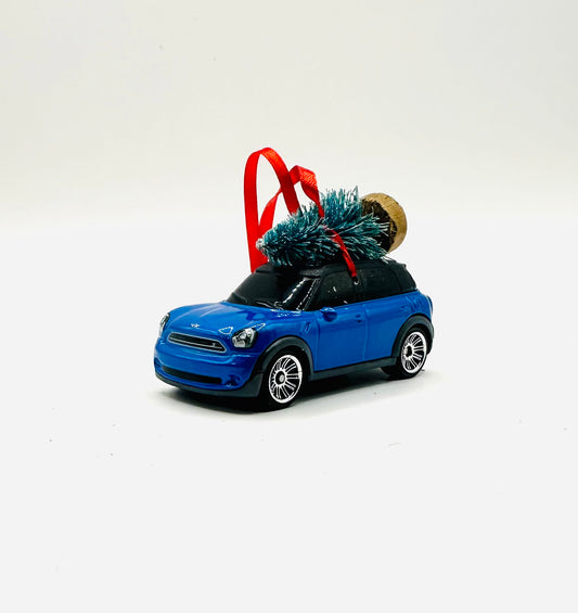 Blue mini countryman car with a Christmas tree on a white background