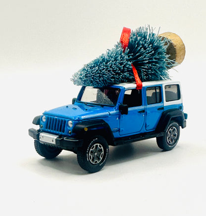 Classic Chief Blue Jeep Wrangler JK Unlimited ornament with festive Christmas tree and red ribbon - angle view