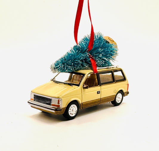 Model diecast mini van ornament with a Christmas tree on top, hanging from a red ribbon against a white background.