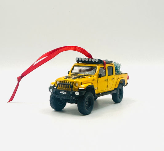Yellow lifted Jeep Gladiator pickup ornament with detailed roof rack and festive Christmas tree with red ribbon - angle view
