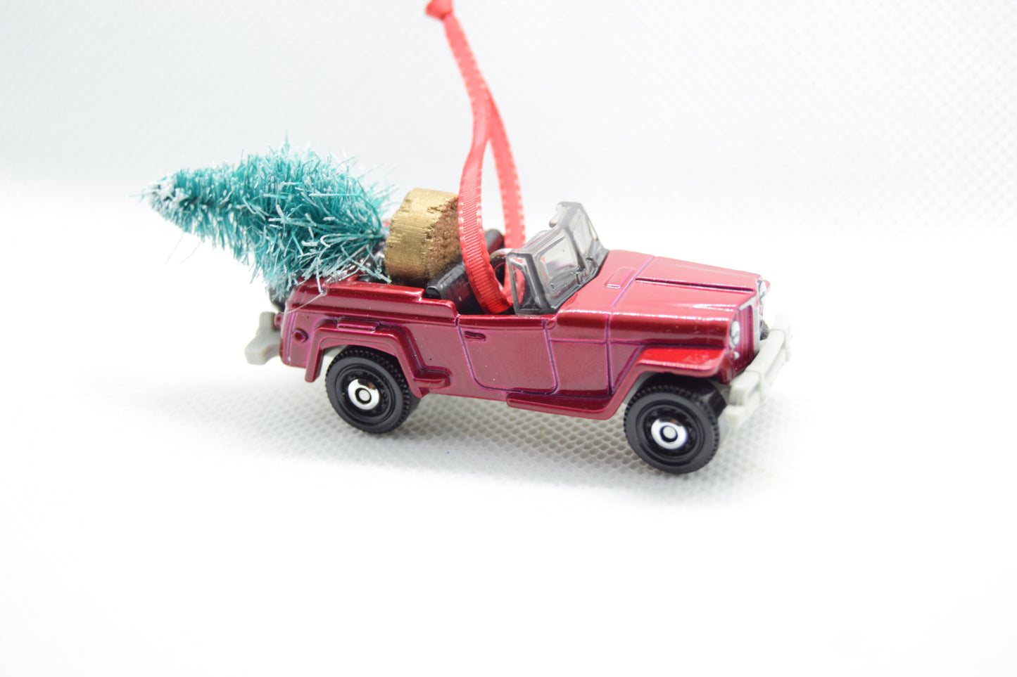 Vintage maroon Jeepster ornament with festive tree and red ribbon