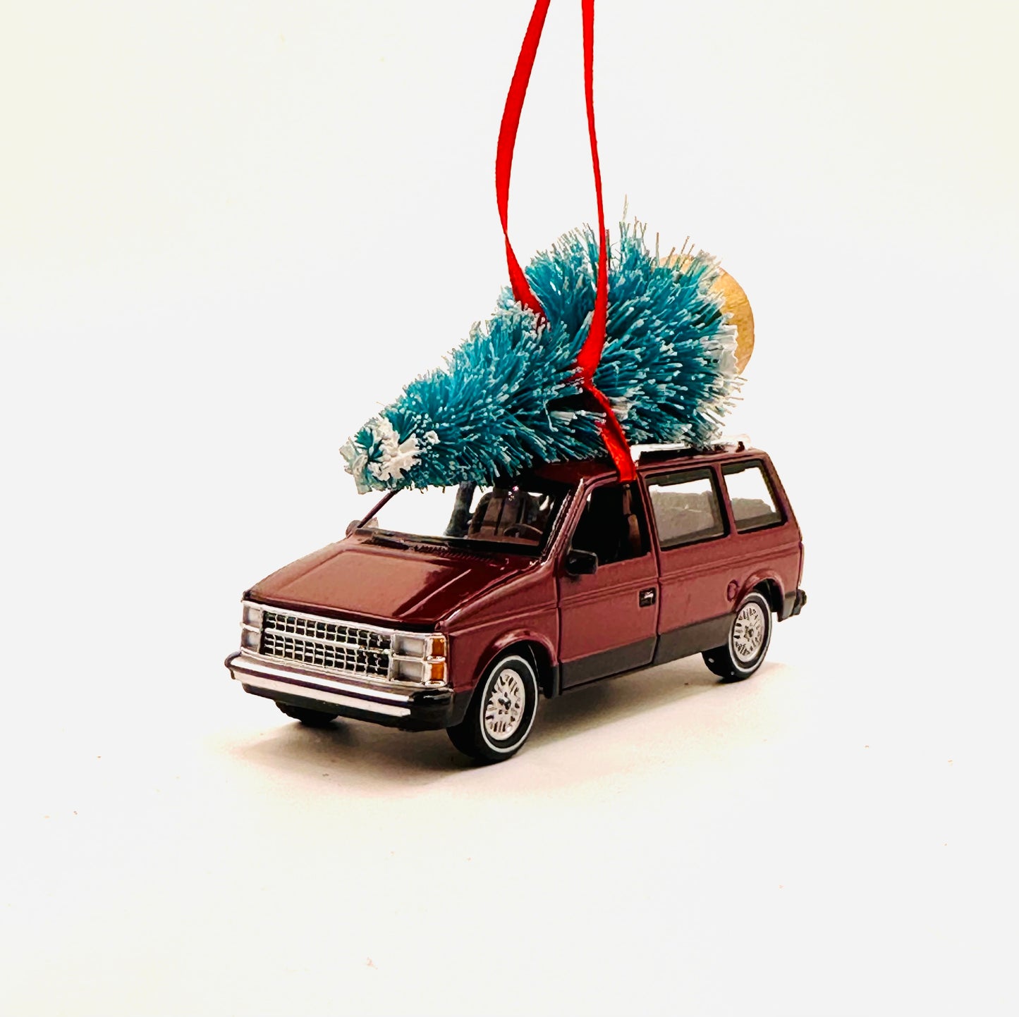 Model minivan ornament with a Christmas tree on a white background