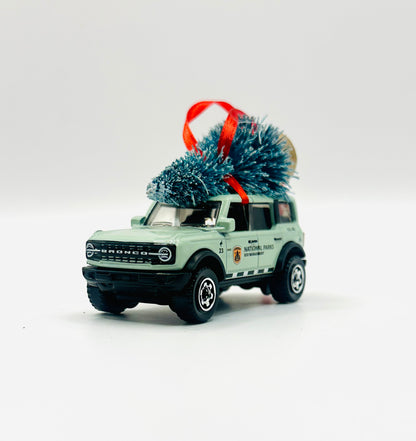 Model of a Ford Bronco with a Christmas tree on top against a white background
