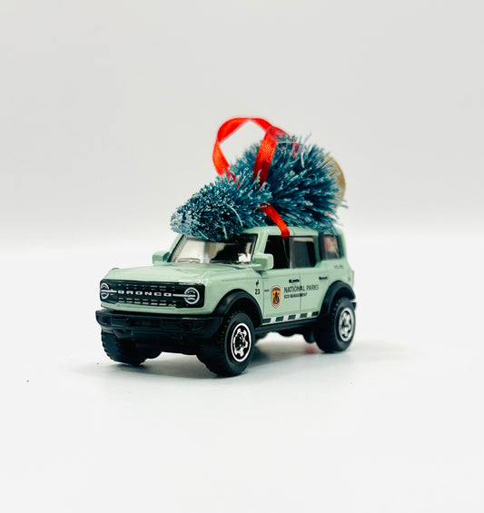 Model of a Ford Bronco with a Christmas tree on top against a white background