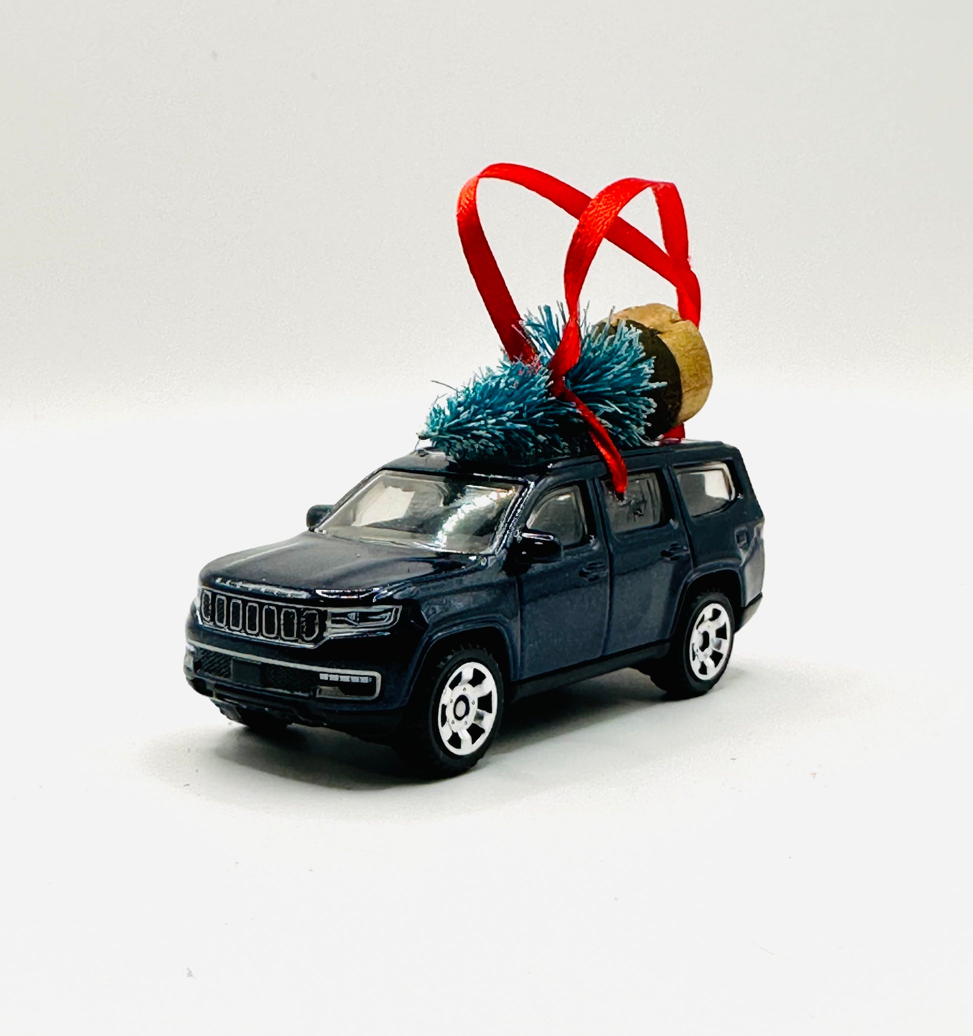 Model SUV Jeep Wagoneer with Christmas tree and ornament on a white background
