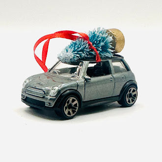 Silver Mini Cooper diecast car ornament with Christmas tree and red ribbon - side angle view